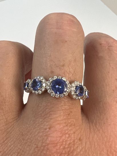 null 18k white gold ring set with five falling tanzanites each surrounded by diamonds....