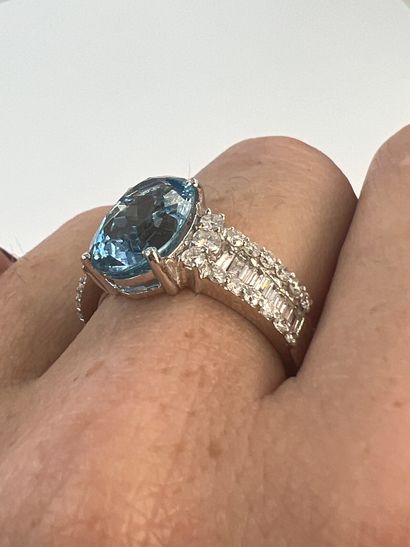null 18k white gold ring set with an aquamarine of about 4 cts. and two lines of...