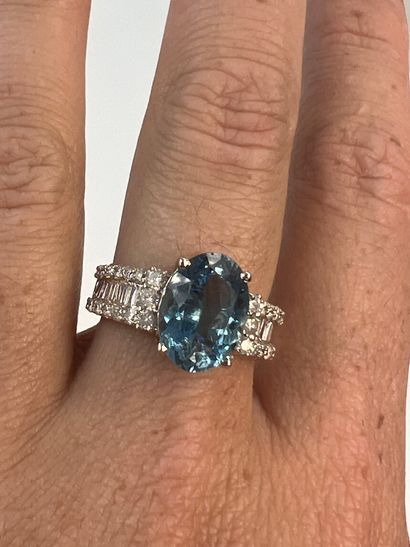 null 18k white gold ring set with an aquamarine of about 4 cts. and two lines of...