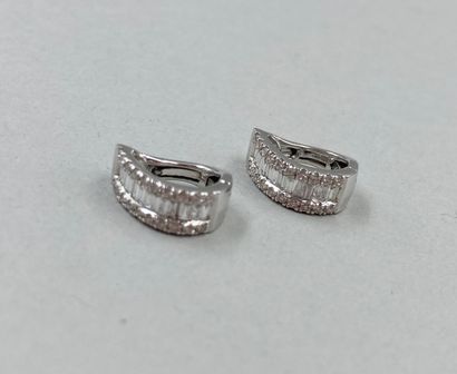 null Pair of 18k white gold ear clips set with a line of tapers diamonds between...