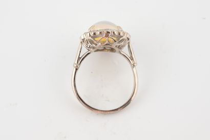 null Bague en or blanc 18k griffée d'une opale ovale dans un entourage de diamants....