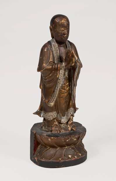 null CHINE, circa 1900.
Sculpture figurant un moine debout les mains jointes, sur...