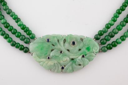 null Collier composé de trois rangs de perles de jade retenant en pendentif une plaque...