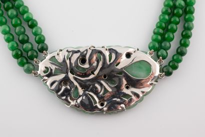 null Collier composé de trois rangs de perles de jade retenant en pendentif une plaque...