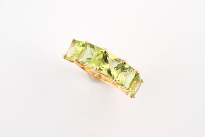 null Bague bandeau en or jaune 18k surmontée de cinq péridots carrés.
Poids brut...