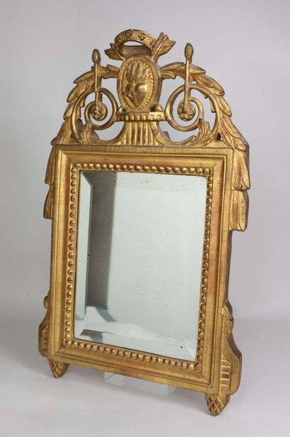 null Petit miroir biseauté à encadrement en bois sculpté doré et ceint d'une frise...