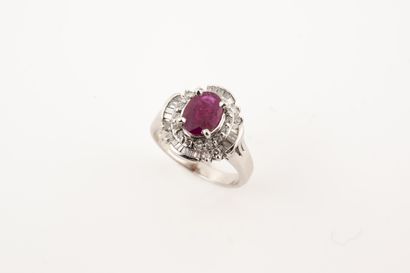 null A platinum skirt ring, centered on an oval ruby of about 1ct in a double setting...