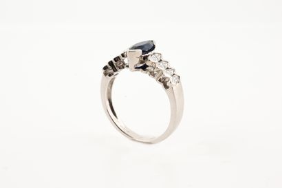 null Design ring in 18k white gold centered on a navette-cut sapphire in a setting...