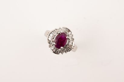 null A platinum skirt ring, centered on an oval ruby of about 1ct in a double setting...