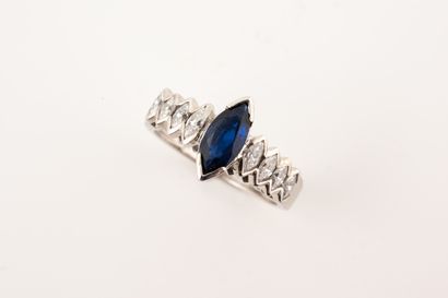 null Design ring in 18k white gold centered on a navette-cut sapphire in a setting...