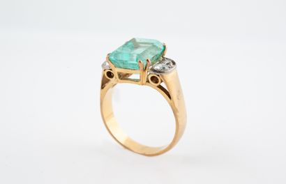 null 18k yellow gold ring set with an emerald cut emerald of about 4 cts. and four...