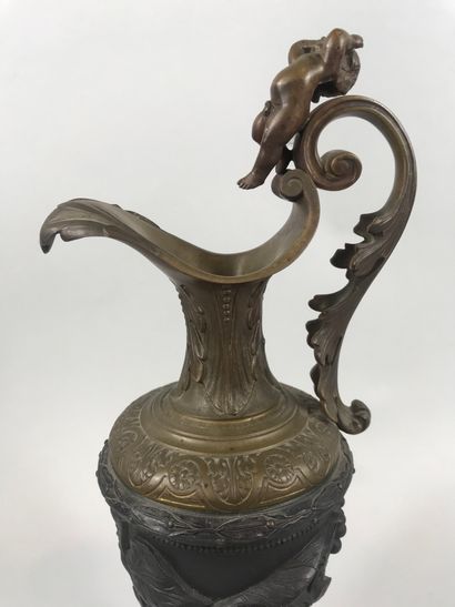 null Ewer in bronze with brown and gilded patina, decorated with vine branches, the...