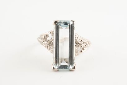 null 18k white gold ring set with an emerald-cut aquamarine flanked by two brilliant-cut...