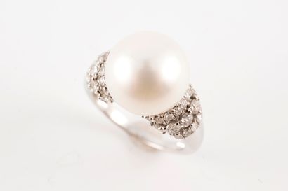 null 18k white gold ring surmounted by a 12mm cultured pearl flanked by three lines...