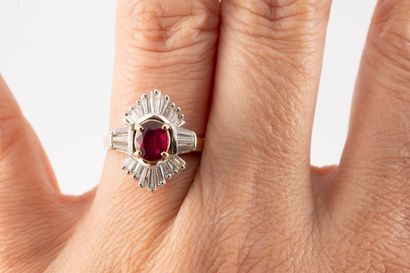 null Two 14k gold ring centered on an oval ruby, approx. 1ct, set in baguette-cut...