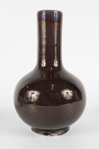 null CHINA, 19th century
Egg-shaped vase with long neck in aubergine-colored enameled...