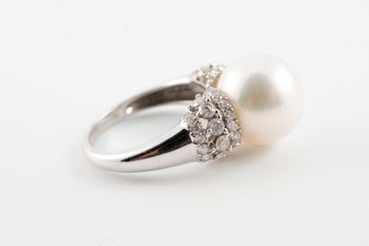 null 18k white gold ring surmounted by a 12mm cultured pearl flanked by three lines...