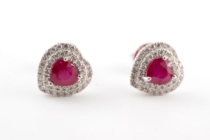 null Pair of 18k white gold heart-shaped stud earrings centered on heart-cut rubies...