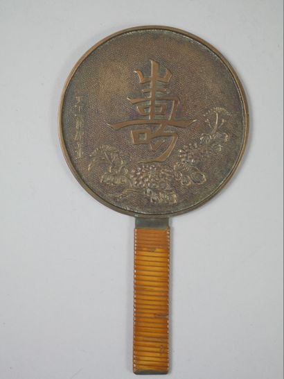 null JAPAN. 
Bronze mirror decorated with flowers and ideograms. Straw-covered handle....
