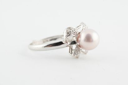 null 18k white gold ring surmounted by a 7mm-diameter pearl set off by a diamond-paved...