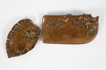 null A set of two bronze pocket-catchers with an insect and holly motif. One signed...