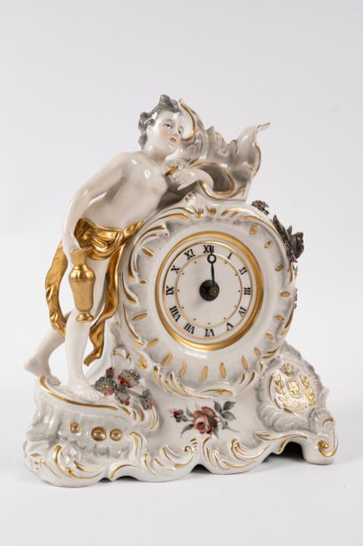 null Porcelain clock depicting a man leaning against the dial. 
Rococo style. Height:...