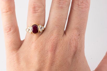null 18k yellow gold ring surmounted by an oval ruby flanked by 6 brilliant-cut diamonds....