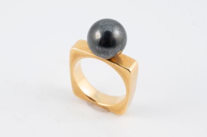 null 18k yellow gold ring topped with a 10mm Tahitian pearl. Square-shaped ring....