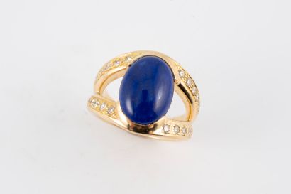 null 18k yellow gold ring surmounted by a lapis lazuli cabochon set between two lines...