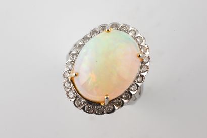 null 18k white gold ring set with a cabochon-cut oval opal in a border of brilliant-cut...