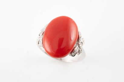null 18k white gold ring set with a coral cabochon flanked by small bows adorned...