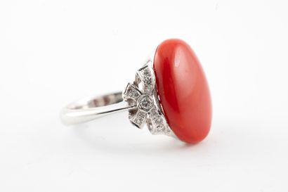 null Bague en or blanc 18k ornée d'un cabochon de corail accosté de petits nœuds...