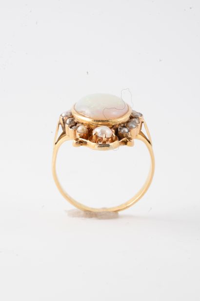 null 18k yellow gold ring set with an oval cabochon opal in an interlaced setting...