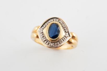null Yellow gold and 18k white gold ring centered on an oval sapphire in a grained...