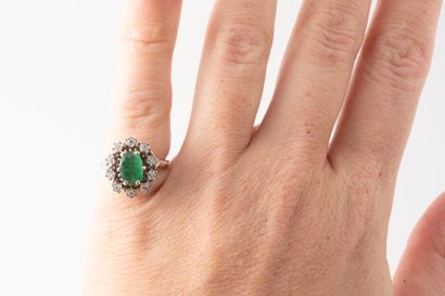 null 18k white gold ring surmounted by an oval emerald in a diamond setting. 
Gross...