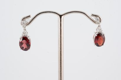 null Pair of earrings in 18k white gold, pendant-set with two oval garnets weighing...