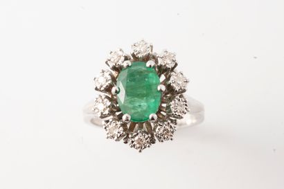 null 18k white gold ring surmounted by an oval emerald in a diamond setting. 
Gross...