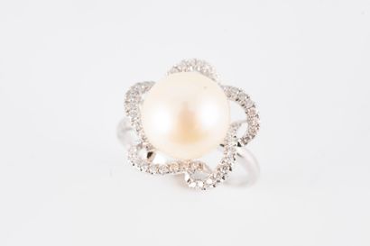null 18k white gold ring centered with a 10mm cultured pearl in an openwork corolla...