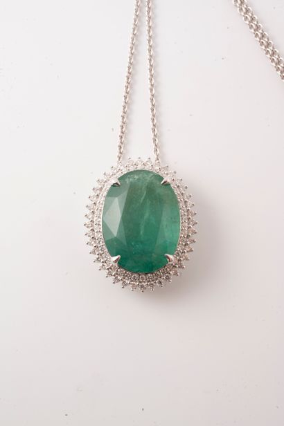 null 18k white gold necklace holding a 14cts oval emerald in a double border of brilliant-cut...