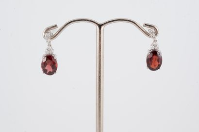 null Pair of earrings in 18k white gold, pendant-set with two oval garnets weighing...