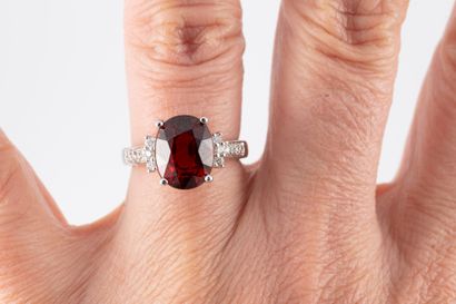 null 18k white gold ring surmounted by an oval spessartite garnet flanked by 6 diamonds....