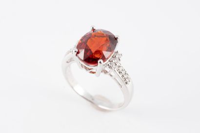 null 18k white gold ring surmounted by an oval spessartite garnet flanked by 6 diamonds....