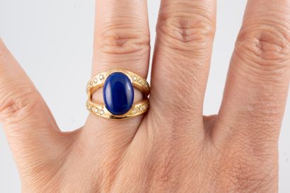 null 18k yellow gold ring surmounted by a lapis lazuli cabochon set between two lines...