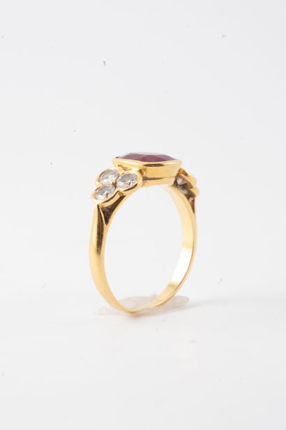 null 18k yellow gold ring surmounted by an oval ruby flanked by 6 brilliant-cut diamonds....