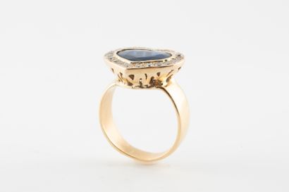 null 18k yellow gold ring surmounted by a heart-cut sapphire in a diamond setting....