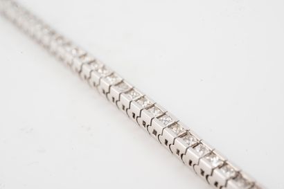 null 18k white gold rivière bracelet set with a line of princess-cut diamonds totaling...
