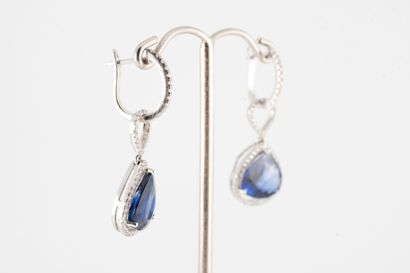 null A pair of platinum earrings holding two probably pear-cut Ceylon sapphires weighing...