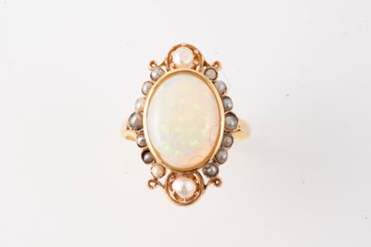 null 18k yellow gold ring set with an oval cabochon opal in an interlaced setting...