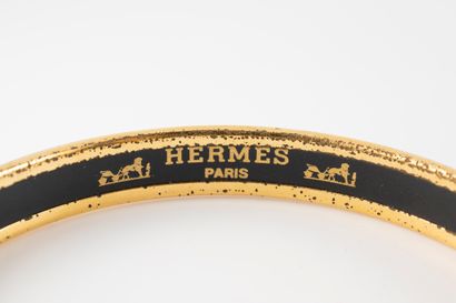 null HERMES Paris 
Bracelet en métal doré et émail à décor de mors sur fond rouge.
Signé....