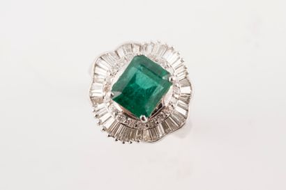 null 18k white gold ring set with an emerald-cut emerald, approx. 2cts, in a scrolled...